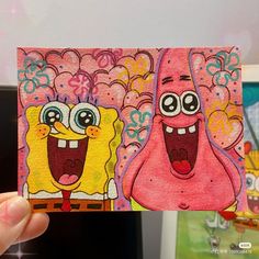 someone holding up a card with two cartoon characters on it