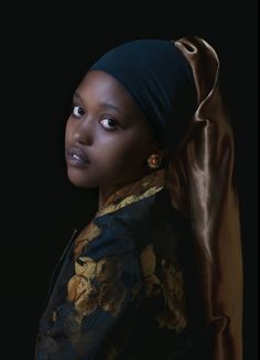 a woman with a head scarf on her head looking off to the side in front of a black background