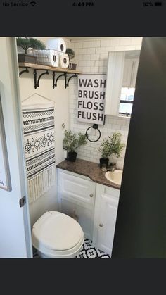 a white toilet sitting in a bathroom next to a sink