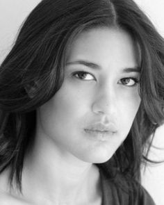 black and white photograph of a woman with long hair looking at the camera, close up