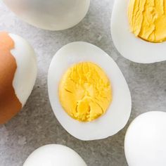 hard boiled eggs on a table with one broken egg in the middle and two whole ones