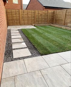 a small garden with grass and stepping stones