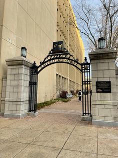 an iron gate with a clock on it in front of a building