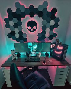 a computer desk topped with a monitor and a keyboard next to a skull wallpaper