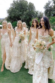 the bridesmaids are all dressed in dresses with flowers on them and holding bouquets