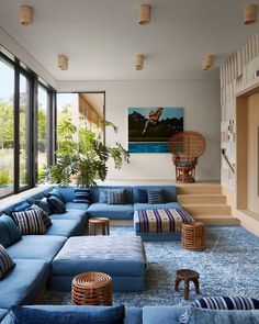 a living room filled with blue couches and pillows