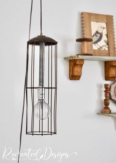 a bird cage hanging from the side of a wall next to shelves with pictures on it