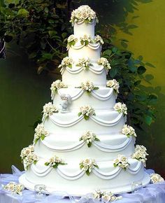 a three tiered wedding cake with white flowers on it