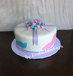 a white cake with blue and pink decorations