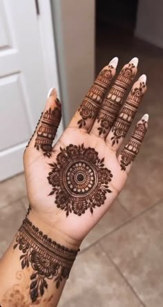 a woman's hand with henna tattoos on it