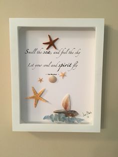 a white frame with shells and starfishs on the wall above it is a poem written in cursive writing