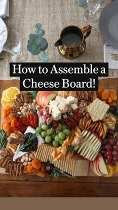 a platter filled with cheese, fruit and crackers on top of a table