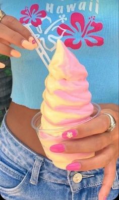 a woman with pink nails is holding an ice cream cone