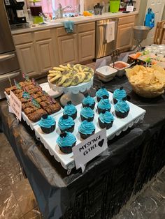 a table topped with lots of cupcakes and other desserts on top of it