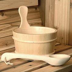 a wooden bowl and spoon sitting on top of a wooden table next to some wood planks