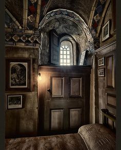 a bedroom with a bed and pictures on the wall next to an open door that has a window above it