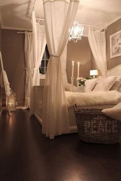 a white canopy bed sitting in a bedroom next to a window