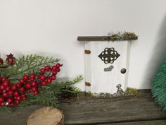 a white birdhouse sitting on top of a wooden table next to a christmas tree