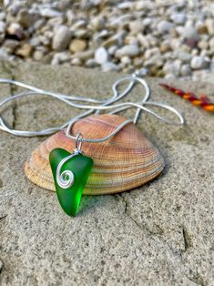 This item is handcrafted from an emerald green piece of genuine Scottish sea glass, combined with silver plated jewellery wire to make a stunning and unique pendant.  The pendant measures approximately 1 cms high and 2 cms wide. The sea glass has a hole drilled through the middle and the wire passes through it to keep the sea glass securely in place.  Sea Glass is the name given to man made glass which has been discarded into the sea, then tumbled and shaped by the sea over many years before bei Green Sea Glass Necklaces For Jewelry Making, Wire Wrapped Silver Recycled Glass Jewelry, Wire Wrapped Silver Jewelry With Recycled Glass, Green Sea Glass Necklace For Jewelry Making, Elegant Green Spiral Jewelry, Wire Wrapped Green Sterling Silver Jewelry, Green Sterling Silver Wire Wrapped Jewelry, Green Wire Wrapped Sterling Silver Jewelry, Green Wire Wrapped Jewelry For Gift