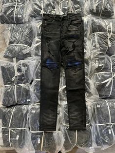 a pile of black jeans sitting on top of plastic bags