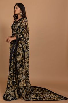 Editor's Note Featuring Varun Bahl's statement floral printed sari highlighted with intricate hand embroidery all over. It is paired with an embroidered black blouse. Fabric: Organza Color: Black Component: Sari, blouse and underskirt Sleeve type: Sleeveless Neckline: V neck Fit: Fitted blouse Embroidery details: Hand embroidery Occasion: Wedding, Festive Blouse length: 14" inches, saree: 5.5 metres, sari width: 45" inches Care: Dry Clean Only About the Designer Varun’s work marries the beauty o Varun Bahl, Cutdana Embroidery, Marriage Dress, Bridesmaid Saree, Floral Print Sarees, Saree Designs Party Wear, Indian Dresses Traditional, Black Saree, Dress Indian Style