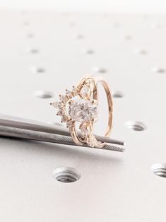 a diamond ring sitting on top of a piece of metal next to a pair of scissors