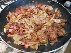 meat and onions cooking in a skillet on the stove top with a spatula