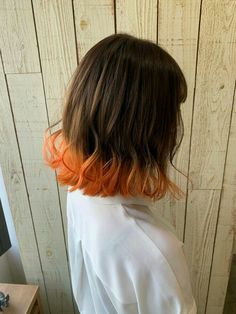 the back of a woman's head with orange and brown hair