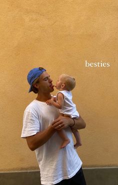 a man holding a baby in his arms with the words besties written on it