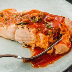 a white plate topped with fish covered in sauce