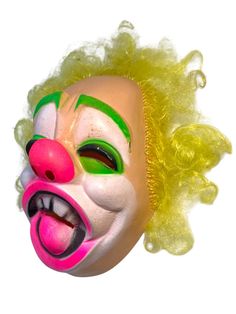 Step back into the playful yet haunting world of 1970s Halloween with this vintage Bayshore Industries clown mask. Known for producing iconic vacuform masks during the mid-20th century, Bayshore Industries became a key player in the Halloween costume industry, crafting lightweight and vividly designed masks like this one. Featuring bright neon accents, this clown mask stands out with its striking UV reactive green eye makeup, neon pink nose, and wild yellow synthetic hair.  Bayshore masks were popular due to their affordability and mass appeal during the peak of trick-or-treating in the 60s and 70s, and they remain highly sought after by collectors today. This mask is in great condition with some minor wear, capturing the essence of a classic retro Halloween. A must-have piece for any seri 1970s Halloween, Makeup Neon, Clown Vintage, Green Eye Makeup, Clown Mask, Green Eye, Uv Reactive, Halloween Vintage, Makeup For Green Eyes