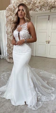 a woman in a white wedding dress posing for the camera with her hands on her hips