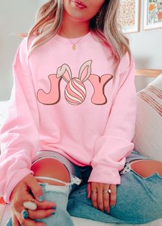 Comfy and super cute, this fun Easter Sweatshirt features a cute retro Joy Easter Bunny graphic on the front and a soft cozy interior. Fit is true to size, for oversized fit, size up 1-2 sizes. Available in super cute colors such as Light Pink, Light Blue, Sand and White. Perfect for Easter season. Free Shipping USA. Be Cozy. Joy Easter Sweatshirt  50% Cotton 50% Poly Medium-heavy fabric  Loose fit crewneck Machine wash cold inside out hang to dry True to size fit, for oversized fit size up Available in Sand, White, Light Pink & Light Blue Free Shipping USA Be Cozy Mom Christmas Shirt, Mama Bear Sweatshirt, Mom Clothing, Coffee Christmas, Christmas Retro, Pink Coffee, Face Graphic, Retro Valentines, Sweater Fits