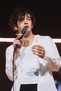 a man with curly hair holding a microphone