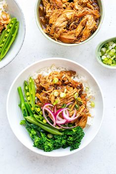 two bowls filled with meat and vegetables on top of a white countertop next to green beans