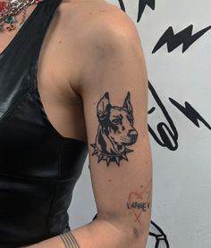 a woman with a dog tattoo on her left arm and right arm behind her back