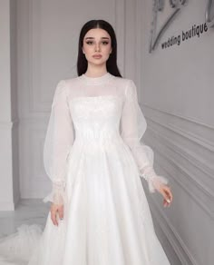 a woman in a white wedding dress posing for the camera