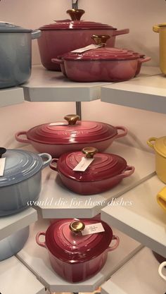 many different pots and pans on display in a store shelf with tags attached to them