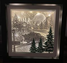 a paper cut christmas scene with a train and trees in the snow at night time