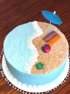 there is a cake that looks like it has an umbrella and beach scenes on it