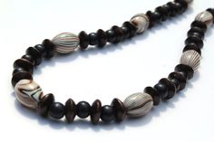 This awesome necklace is made up of dark brown and black wood beads (which are great because they are so light in weight), as well as striped acrylic beads.  The style of this necklace is so unique and includes various shapes and sizes to give it great character...there's almost a little wild feel to it! This necklace is available in 4 different lengths.  Please choose your preference when you add it to the cart.  It is available in approximate lengths of 33, 28, 23, and 18 inches. Oval acrylic beads are 20mm. This necklace is an original.  It was designed, created, and handmade by Michele of MichelesAManoDesigns. PLEASE NOTE:  My items are created only for sale on Etsy or on my website https://michelesamanodesigns.patternbyetsy.com If you see this listing anywhere else, it has been stolen Toddler Necklace, Lavender Necklace, Chunky Bead Necklace, Purple Bead Necklace, Brown Beaded Necklace, Eyeglass Necklace, Chunky Bead Necklaces, Daisy Jewelry, Wooden Bead Necklaces