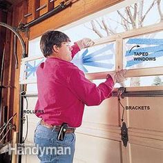 a man in pink shirt and jeans working on a garage door with window sealer