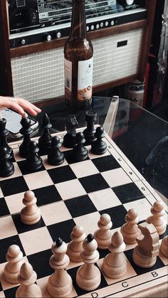 a person playing chess with a bottle of wine