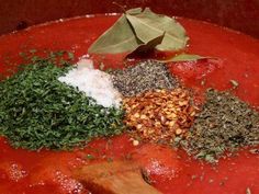 spices and herbs are mixed together in a red sauce