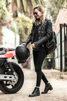 a woman walking down a street next to a motorcycle