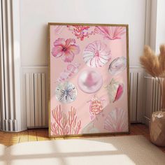 a pink painting with seashells and flowers on the wall next to a potted plant