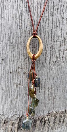 "Cast bronze organic hammered 1.25\" oval pendant long lariat necklace with 6 variegated step cut labradorite nugget beads. The 1.5 mm leather cord is adjustable and finished with black pearls. It can expand from 18'-36\" Great for every day and layering with other necklaces. Also available in sterling silver. Labradorite A Bringer of Light Labradorite is a highly mystical and protective stone. It raises consciousness and deflects unwanted energies. It calms an overactive mind and energizes the Artisan Hand Wrapped Oval Pendant Necklace, Artisan Oval Hand-wrapped Jewelry, Artisan Hand Wrapped Oval Jewelry, Hammered Spiritual Necklaces With Adjustable Fit, Spiritual Hammered Adjustable Necklace, Artisan Oval Brass Jewelry, Rustic Gold Dangle Jewelry, Adjustable Hammered Spiritual Necklaces, Hand Forged Adjustable Oval Jewelry