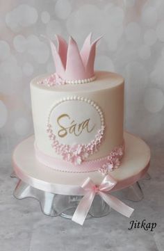 a pink and white cake with a crown on top