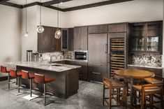 a kitchen with an island and bar stools next to the counter top in front of it