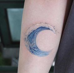 a blue wave tattoo on the left arm